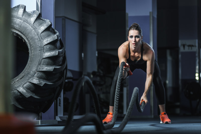 Female Athlete Working Out With Battle Ropes
